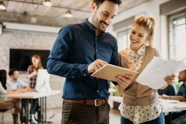 Two professionals collaborating in an energetic office, preparing content for strategic business video tips